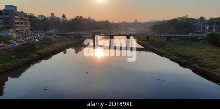 Un reflet du coucher du soleil capture sur la rivière mutha depuis le pont shivaji pune. La dune polluée de la mutha. Banque D'Images