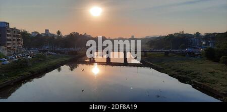 Un reflet du coucher du soleil capture sur la rivière mutha depuis le pont shivaji pune. La dune polluée de la mutha. Banque D'Images