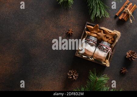 Délicieux cadeau de Noël pour faire des boissons au chocolat et des biscuits faits maison sur fond marron. Espace pour le texte. Vue de dessus. Banque D'Images