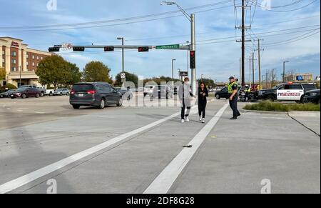 Allen, TX USA - 27 novembre 2020 : vue sur la route d'un policier aidant le piéton à traverser la route Banque D'Images