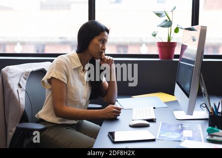 Femme d'affaires de race mixte utilisant l'ordinateur dans le bureau Banque D'Images