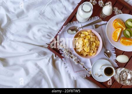 Petit déjeuner romantique au lit avec fleurs printanières. Flat lay, espace de copie Banque D'Images