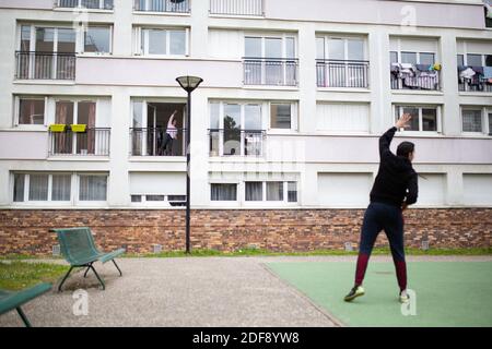 Un entraîneur sportif donne un cours de gymnastique aux résidents d'un quartier de classe ouvrière à Suresnes, banlieue de Paris, France le 3 avril 2020 en confinement pendant quelques semaines. Deux résidents et membres de l'association collectif solidaire des Chènes Ismael Ichaoui et Smail Belkacem ont décidé de donner, trois fois par semaine, des leçons sportives aux personnes sur leur balcon. Photo de Raphael Lafargue/ABACAPRESS.COM Banque D'Images