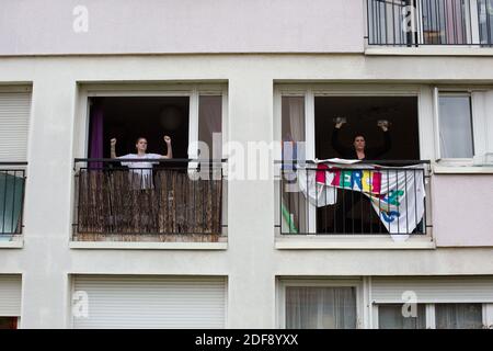 Un entraîneur sportif donne un cours de gymnastique aux résidents d'un quartier de classe ouvrière à Suresnes, banlieue de Paris, France le 3 avril 2020 en confinement pendant quelques semaines. Deux résidents et membres de l'association collectif solidaire des Chènes Ismael Ichaoui et Smail Belkacem ont décidé de donner, trois fois par semaine, des leçons sportives aux personnes sur leur balcon. Photo de Raphael Lafargue/ABACAPRESS.COM Banque D'Images