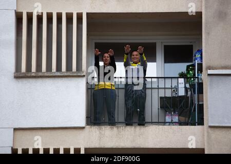 Un entraîneur sportif donne un cours de gymnastique aux résidents d'un quartier de classe ouvrière à Suresnes, banlieue de Paris, France le 3 avril 2020 en confinement pendant quelques semaines. Deux résidents et membres de l'association collectif solidaire des Chènes Ismael Ichaoui et Smail Belkacem ont décidé de donner, trois fois par semaine, des leçons sportives aux personnes sur leur balcon. Photo de Raphael Lafargue/ABACAPRESS.COM Banque D'Images