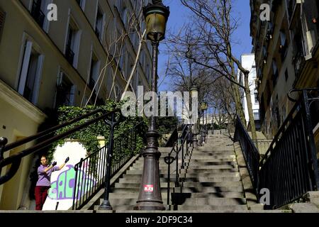 Une jeune femme parisienne confinée exerce le Tai Chi sur sa terrasse dans le quartier de Montmartre pendant le confinement imposé pour ralentir la propagation du coronavirus (COVID-19) à Paris. Après l'annonce par le président français Emmanuel Macron des règles strictes de confinement à domicile des Français en raison d'une épidémie de Pandémie de coronavirus (COVID-19) le 18 mars 2020 à Paris, France. Les Français devront rester chez eux, la France a fermé toutes les écoles, théâtres, cinémas et une gamme de magasins, seuls ceux qui vendent de la nourriture et d'autres articles essentiels étant autorisés à rester ouverts Banque D'Images