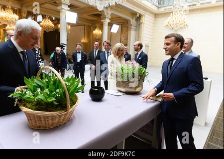 Stephane Layani, Brigitte et Emmanuel Macron lors d'une réception sur le commerce alimentaire local à l'Elysée Palace, Paris, France, le 1er mai 2020. Le président français Macron et sa femme Brigitte Macron reçoivent un bouquet de nénuphars de la vallée. Photo de Jacques Witt/¨Pool/ABACAPRESS.COM Banque D'Images