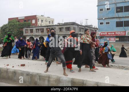 Les ouvriers bangladais du vêtement lancent des briques vers la police lors d'un affrontement à Dhaka, au Bangladesh, le 20 mai 2020. Les travailleurs de l'habillement sont descendus dans la rue pour protester, risquant ainsi d'être exposés à Covid-19, exigeant de savoir quand ils recevraient leur salaire dû. Photo de Kanti Das Suvra/ABACAPRESS.COM Banque D'Images