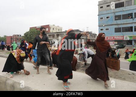 Les ouvriers bangladais du vêtement lancent des briques vers la police lors d'un affrontement à Dhaka, au Bangladesh, le 20 mai 2020. Les travailleurs de l'habillement sont descendus dans la rue pour protester, risquant ainsi d'être exposés à Covid-19, exigeant de savoir quand ils recevraient leur salaire dû. Photo de Kanti Das Suvra/ABACAPRESS.COM Banque D'Images