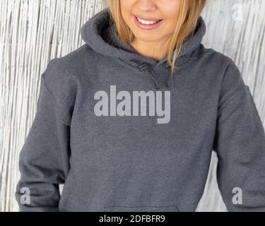 Une femme qui se remplit de taches non reconnaissables porte un sweat à capuche gris. Fermer la vue de l'espace de copie. Maquette de mode. Conception de vêtements. Banque D'Images