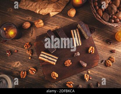 Barres Gerbeaud remplies de marmelade de prune et de noix écrasées, recouvertes de glaçage au chocolat sur fond de bois Banque D'Images