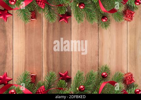 Les feuilles des arbres de Noël avec des ornements rouges sur fond de bois, de la conception à la frontière Banque D'Images