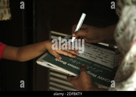 Karachi. 3 décembre 2020. Un agent de santé marque le doigt d'un enfant après avoir administré le vaccin contre la polio lors d'une campagne de vaccination de porte à porte dans la ville portuaire de Karachi, dans le sud du Pakistan, le 3 décembre 2020. Crédit : Ahmad Kamal/Xinhua/Alamy Live News Banque D'Images