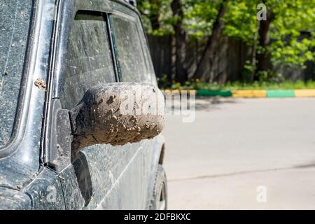 Le rétroviseur latéral de la voiture est éclaboussé de boue et de terre. Véhicule tout-terrain après avoir roulé sur sol argileux, véhicule sale en gros plan Banque D'Images