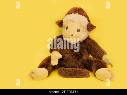 Singe en peluche sur fond jaune gros plan. Banque D'Images