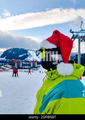 joyeux homme en tenue de ski avec chapeau de noël rouge père noël en hiver, les montagnes de la colline de l'espace de copie Banque D'Images