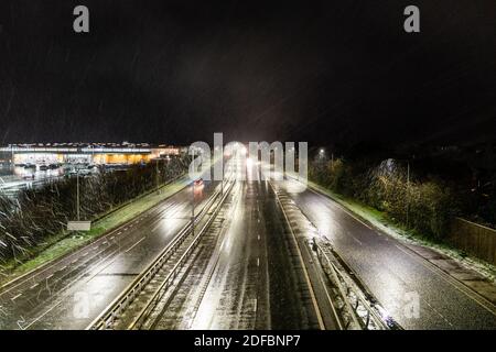 Vue en hauteur de la circulation routière de nuit sur la route principale, A299, Thanet Way dans le Kent, pendant une chute de neige. Les phares de la voiture se rapprochant du spectateur, de la neige et de la chute du traîneau . Banque D'Images