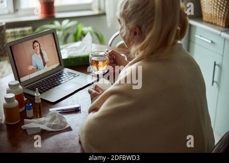 Femme âgée parlant avec un médecin par appel vidéo Banque D'Images