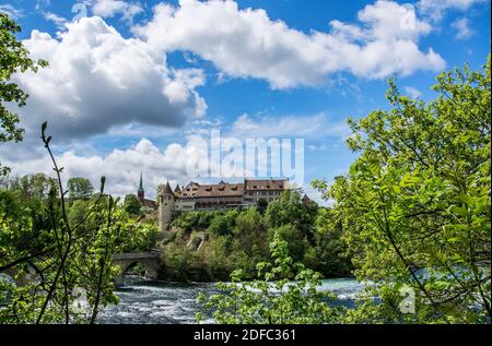 DAS Schloss liegt am linken Ufer des Rheins auf einem steilen Felsen über dem Rheinfall und bietet einen Ausblick über den Rhein und den Wasserfall. Banque D'Images