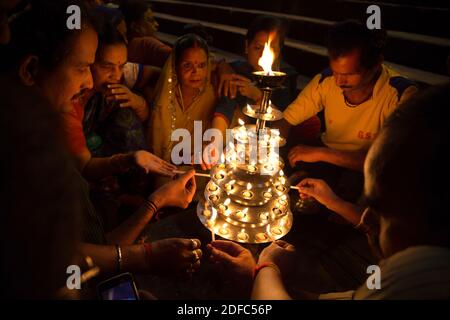 Inde, pèlerins hindous éclairant des bougies sur un ghat à Varanasi Banque D'Images