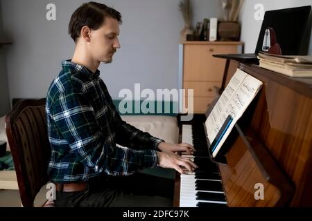 Professeur jouant du piano pendant sa leçon en ligne Banque D'Images