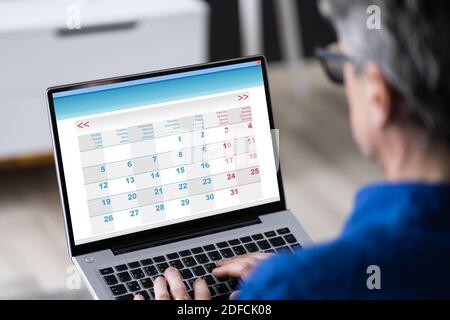 Homme utilisant l'Agenda du calendrier sur un ordinateur portable Banque D'Images