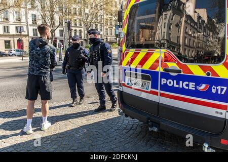 POLICE NATIONALE VÉRIFIANT L'AUTORISATION PERSONNELLE DE QUITTER SON DOMICILE PENDANT L'ISOLEMENT DE LA PANDÉMIE COVID-19, QUAI DE L'HÔTEL DE VILLE, PARIS, ILE DE FRANCE Banque D'Images