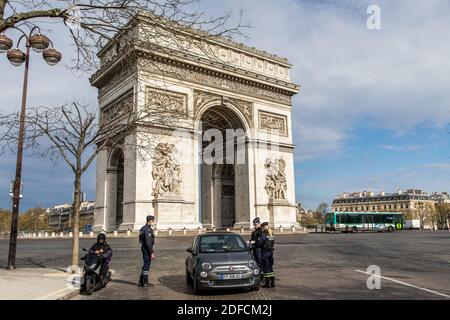 POLICE NATIONALE VÉRIFIANT L'AUTORISATION PERSONNELLE DE QUITTER SON DOMICILE PENDANT L'ISOLEMENT DE LA PANDÉMIE COVID-19, ARC DE TRIOMPHE, PLACE DE L'ETOILE, PARIS, ILE DE FRANCE Banque D'Images