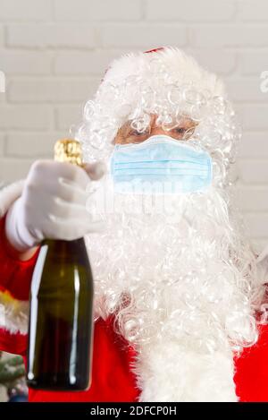 Homme en costume du Père Noël portant une gaze de sécurité masque médical. Banque D'Images