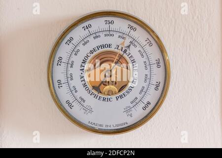 Un baromètre de pression atmosphérique, fabriqué par l'URSS et encadré d'or, accroché à un mur. L'instrument se trouve à l'intérieur du verre en blanc. Il affiche des chiffres Banque D'Images