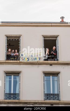 BANNER 'ON VA S'EN SORTIR SANS SORTIR' (NOUS ALLONS SORTIR DE CETTE SITUATION EN NE SORTANT PAS), ISABELLE, UNE INFIRMIÈRE, OLIVIER ET LEURS TROIS FILLES SOUTIENNENT LES TRAVAILLEURS DE LA SANTÉ, TOUS LES SOIRS À 20H ILS APPLAUDISSENT TOUS LES TRAVAILLEURS DE LA SANTÉ PENDANT LE CONFINEMENT PANDÉMIQUE COVID-19, CHARENTON LE PONT, ILE DE FRANCE Banque D'Images