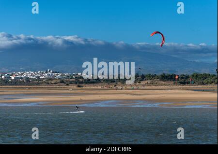 Alvor, Portugal - 17 août 2020 : kite surfeurs à l'estuaire d'Alvor près de la ville d'Alvor, en Algarve, Portugal, avec la montagne Monchique sur le Banque D'Images