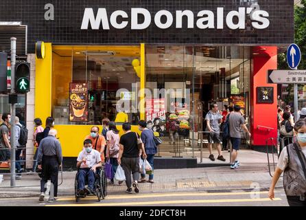 27 novembre 2020, Hong Kong, Chine : des piétons portant des masques traversent la rue au feu de circulation devant la chaîne multinationale américaine de restauration rapide McDonald's à Hong Kong. (Image de crédit : © Budrul Chukrut/SOPA Images via ZUMA Wire) Banque D'Images