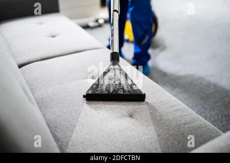Service professionnel de nettoyage de canapé en utilisant l'aspirateur Banque D'Images
