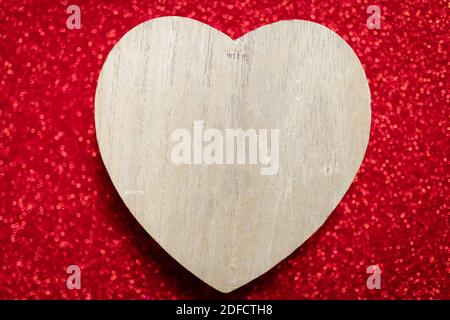 Un fond rouge étincelant, rhinestone, cadeau de la Saint-Valentin pour la seconde moitié, une photo romantique, un coeur en bois sur un fond rouge, adapté pour te Banque D'Images