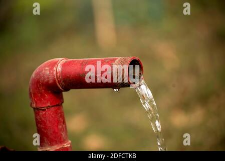 Gaspillage d'eau. De l'eau douce s'écoule d'un tuyau en acier. Banque D'Images