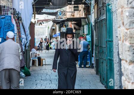 Vue sur la rue Al-Wad dans la vieille ville de Jérusalem, Israël avec promenade juive orthodoxe dans la rue. Banque D'Images