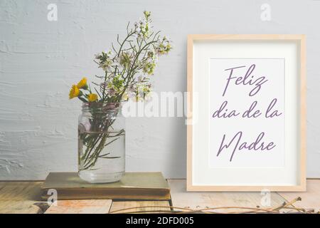 Carte de fête des mères en espagnol dans un cadre en bois à côté de quelques fleurs dans un pot. Espace de copie vide pour le texte de l'éditeur, Banque D'Images