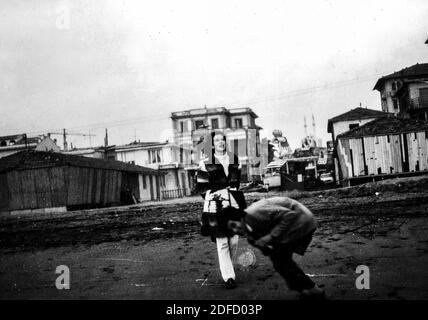 Années 1960, années 1970 Jeune couple de la mer en plein air en noir et blanc s'amuser à la plage de Castinglioncello en Toscane. Italie. Numérisation des rayures et des imperfections Banque D'Images