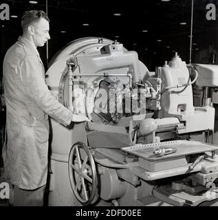 Années 1950, historique, un opérateur masculin qui supervise le fonctionnement d'un grand tour refroidi par eau à l'usine GEC en ??? Banque D'Images