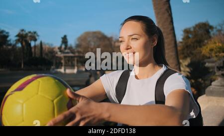 Jolie fille sportive avec un sac à dos et un ballon de football qui se repose bien magnifique parc Banque D'Images