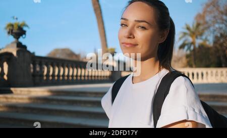 Portrait d'une jolie fille souriante avec sac à dos en toute confiance caméra extérieure Banque D'Images