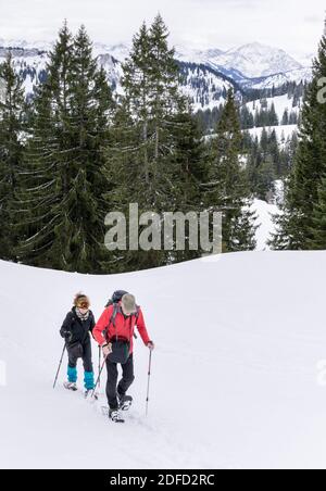 Le couple senior fait de la randonnée en raquettes dans les montagnes alpines d'hiver. Allgau, Bavière, Allemagne. Banque D'Images