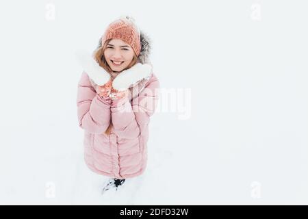 Fille posant à l'extérieur, une femme regarde une jeune femme souriante et heureuse dans les vêtements de ski de plein air loisirs par temps froid, image pour la publicité, insérer t Banque D'Images