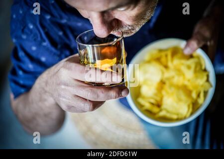 Homme mangeant des chips de pommes de terre. Banque D'Images