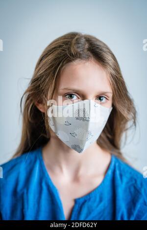 Enfant de 11 ans portant un masque de protection pendant la pandémie de Covid 19. Banque D'Images