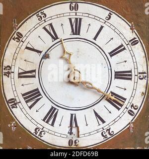 Horloge ancienne avec chiffres romains et arrière-plan brun abîmé Banque D'Images