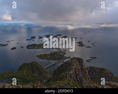 Superbe vue panoramique aérienne du village de pêcheurs Henningsvær situé sur plusieurs îles en face d'Austvågøya, Lofoten, Norvège avec des montagnes accidentées. Banque D'Images