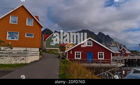 Maisons traditionnelles norvégiennes en bois dans le village de pêcheurs de Henningsvær, Lofoten, Norvège avec façades peintes dans de belles couleurs rouge, orange et vert. Banque D'Images