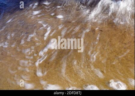 Vagues sur la grève acquise avec une vitesse d'obturation lente. Résumé fond naturel de mouvement. Banque D'Images